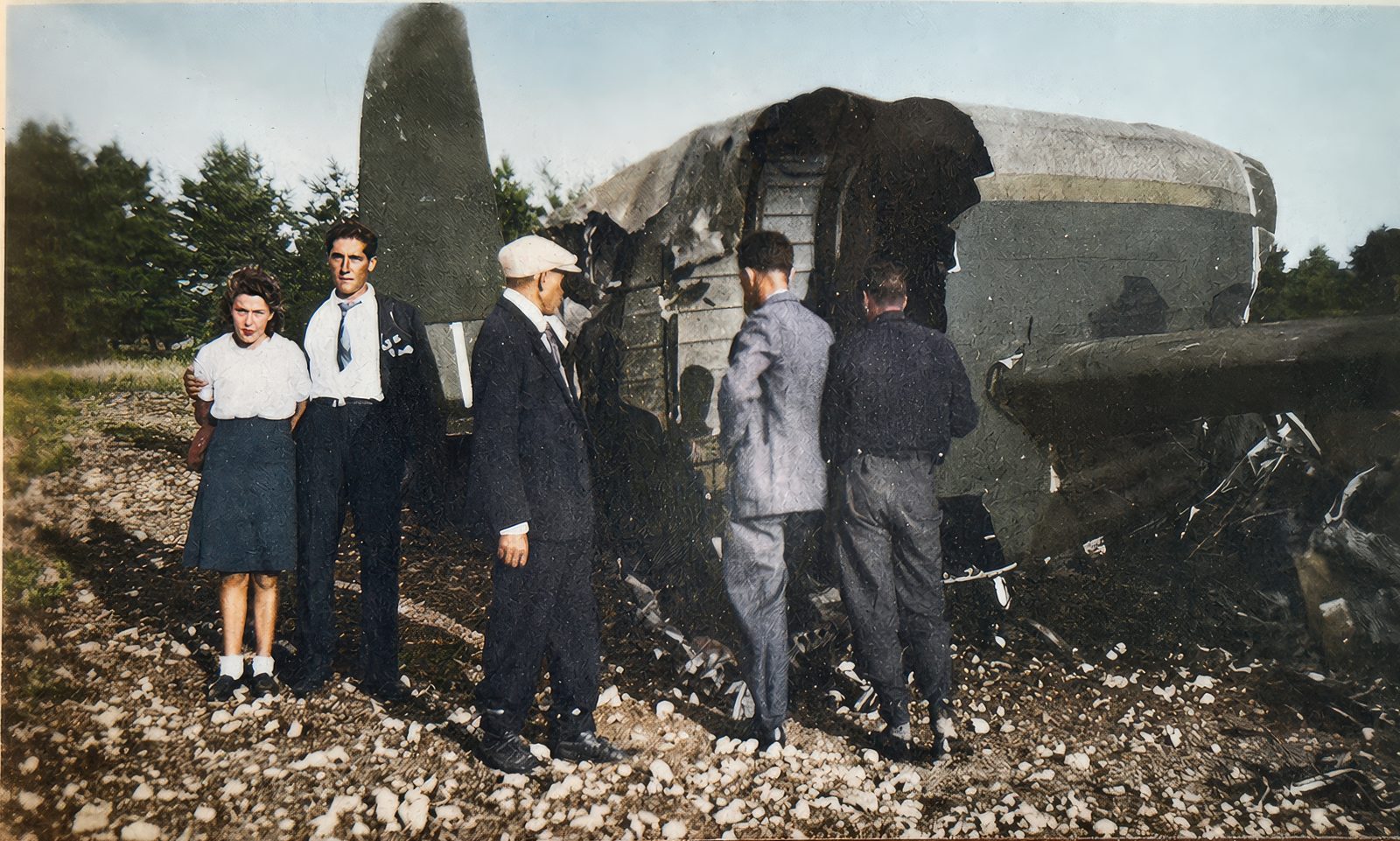 A young couple and three men standing beside the broken tail section of the Lancaster